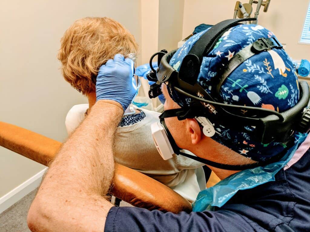 david glen performing ear wax removal procedure in ppe